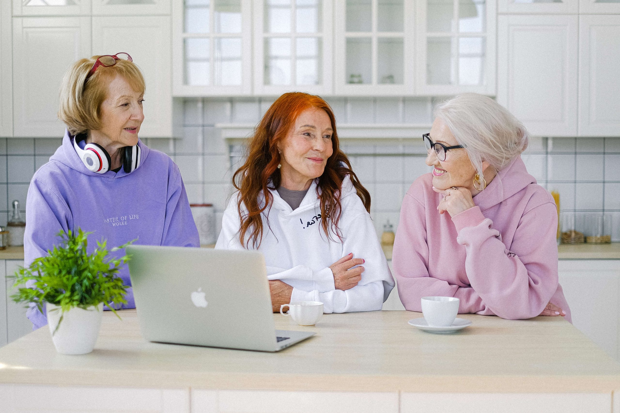 Trois femmes seniors se retrouvant dans la cuisine d'une maison